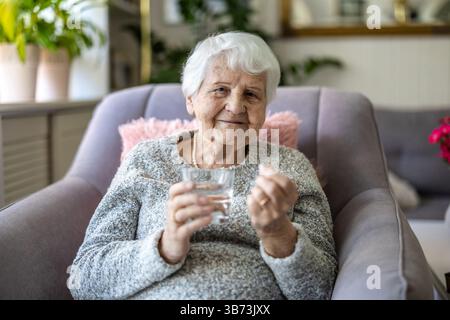 Senior woman taking her medication Stock Photo
