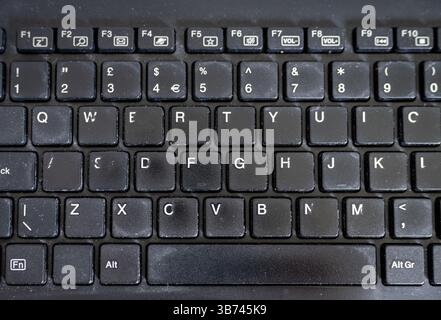 Close up of black computer keyboard. Old and worn. No branding. Stock Photo