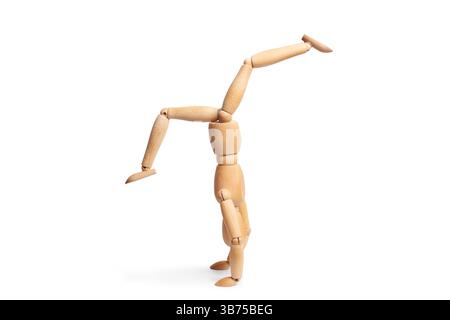 A wooden mannequin doing a handstand on white background with copy space Stock Photo