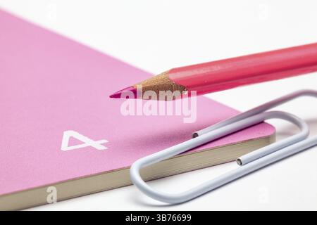 Organizer for the month of April, pink pencil and white paperclip on the white table Stock Photo