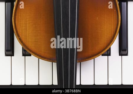 Very old violin lying on the piano Stock Photo