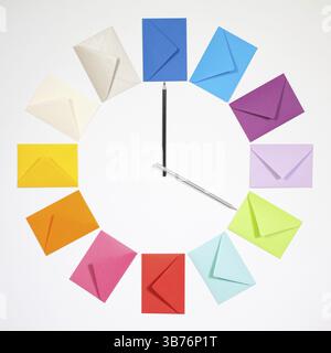 Twelve envelopes isolated on white background. Clock of colored envelopes for Christmas mailing Stock Photo