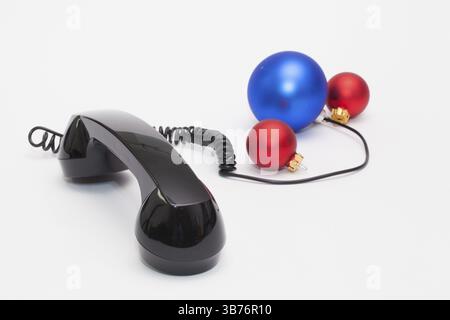 Old phone reciever and cord connection with Christmas decoration. Christmas hotline concept Stock Photo