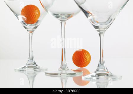 Three glasses of champagne and golf equipments on the glass table Stock Photo