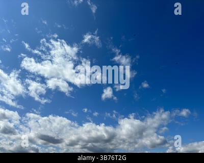 The bright blue sky is filled with fluffy white clouds creating a beautiful, sunny day. Stock Photo