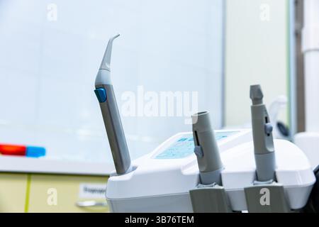 This image showcases a close-up view of a dental handpiece alongside complementary dental tools in a clean, modern dental office, highlighting advance Stock Photo