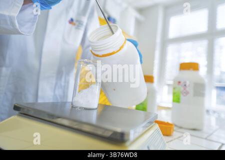 A white bottle fills substance into a beaker on a scale, Nagold Youth Research Centre, Black Forest North, Calw district, Germany, Europe Stock Photo