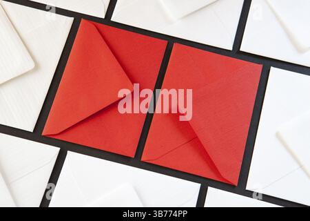 Composition with white and red envelopes on the table. Different colored envelopes on the table Stock Photo