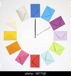 Twelve envelopes isolated on white background. Clock of colored envelopes for Christmas mailing Stock Photo