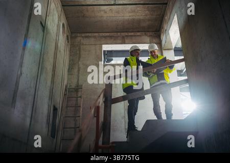 Construction managers reviewing blueprints or project plans. Stock Photo
