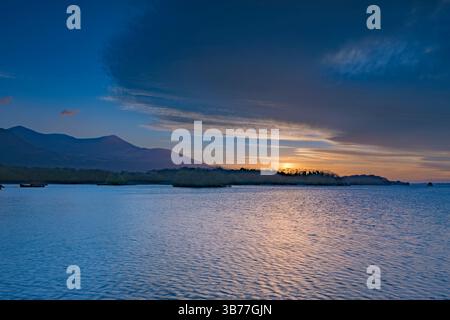 Sun Setting at Lough Leane (Loch Léin) with Dramatic Clouds at Killarney National Park, County Kerry, Ireland Stock Photo