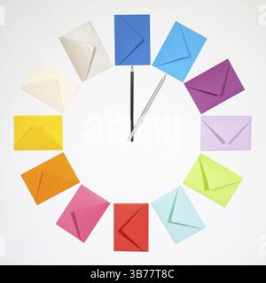 Twelve envelopes isolated on white background. Clock of colored envelopes for Christmas mailing Stock Photo