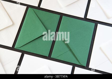 Composition with white and green envelopes on the table. Different colored envelopes on the table Stock Photo
