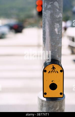 Traffic light switch button. Yellow button on traffic lights on the road with pedestrian crossing Stock Photo