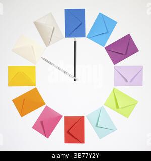 Twelve envelopes isolated on white background. Clock of colored envelopes for Christmas mailing Stock Photo