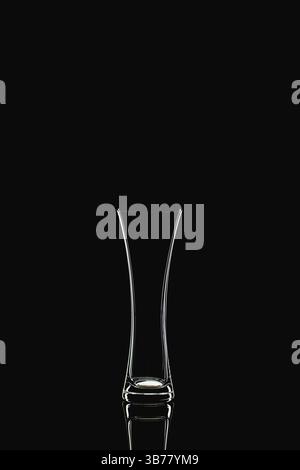 Glass vase, isolated on the black background. Empty glass vase with reflection on black glass table Stock Photo