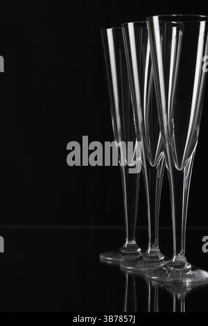 Three empty champagne glasses on a glass plate Stock Photo
