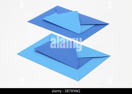 Jigsaw puzzle from big and small blue envelopes on the white table. Funny envelopes concept Stock Photo