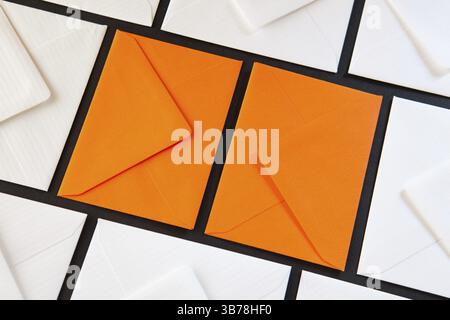 Composition with white and orange envelopes on the table. Different colored envelopes on the table Stock Photo