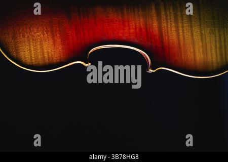 Detail of old violin music instrument of orchestra closeup isolated on black. Silhouette of a violin on black background with copy space for music con Stock Photo