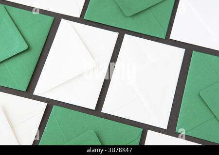 Composition with white and green envelopes on the table. Different colored envelopes on the table Stock Photo