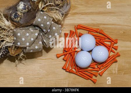 Easter wreath with dry grass, pine cones, feathers, quail eggs and golf balls on the wooden table Stock Photo