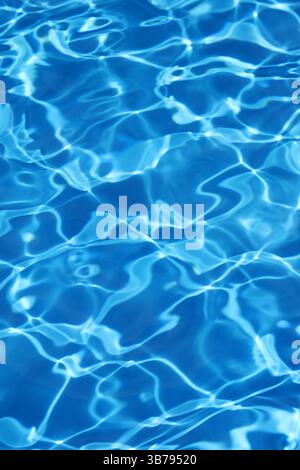 Light ripples reflecting in blue water background of swimming pool Stock Photo