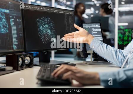 Close up of programmer looking at computer monitor in data center, managing server virtualization, running scripts. Worker using programming language on PC screen in server farm Stock Photo