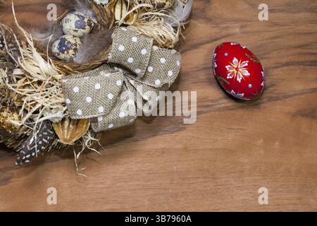Easter wreath with dry grass, pine cones, feathers, quail and Easter eggs on the wooden table Stock Photo