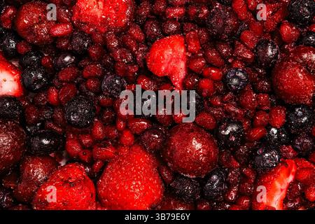 Various frozen mixed berries close-up in vibrant red and deep blue hues Stock Photo