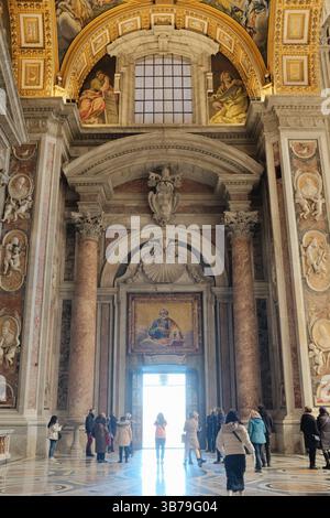 holy door Ornate marble columns and wide hallway inside entrance of Saint Peters Basilica in Vatican City with tourists walking under soft natural light. High quality photo Stock Photo