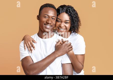 Portrait of loving african couple posing on yellow Stock Photo