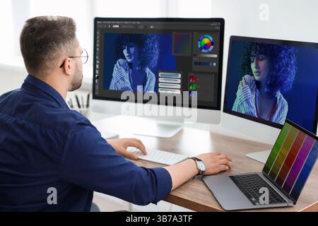 Designer working on different computers at table in office Stock Photo