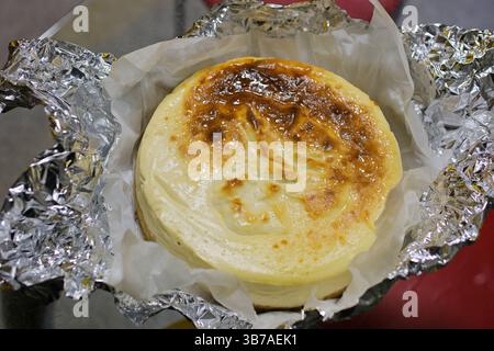 Basque burnt cheesecake on wooden table in baking room. High quality 4k footage Stock Photo