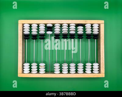 Russian old wooden abacus made of black and white pebbles and beige frame on dark green background in the center top view Stock Photo