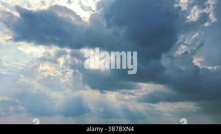 blue sky with bright light between the white clouds Stock Photo