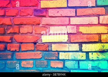 Colorful brick wall made of handmade clay bricks. Abstract bricks background. Bright pink green gradient colored Stock Photo