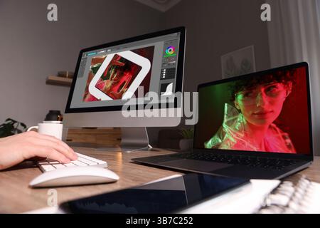 Designer working on different computers at table in office, closeup Stock Photo