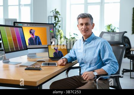 Designer working on different computers at table in office Stock Photo
