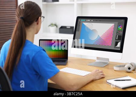 Designer working on different computers at table in office Stock Photo
