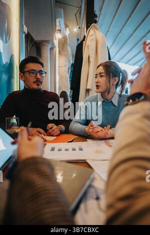 Young colleagues collaborating on a project during a meeting at a cafe Stock Photo