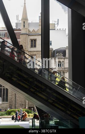 People ride an escalator at the Leadenhall Building in London, UK. Stock Photo
