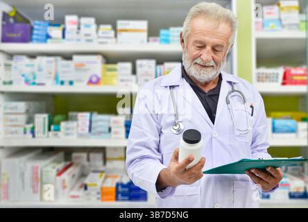 Senior doctor looking medicine bottle and patient chart on medicine shelves background,Pharmacist filling prescription in pharmacy drugstore. Stock Photo