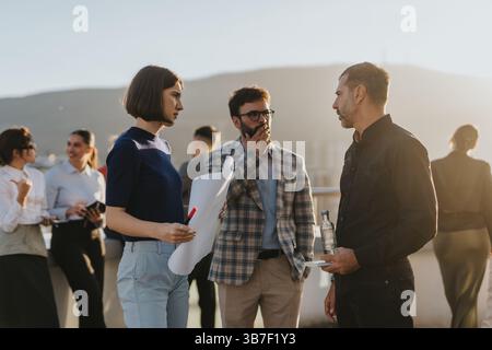 Business team discussing project solutions on a rooftop balcony Stock Photo