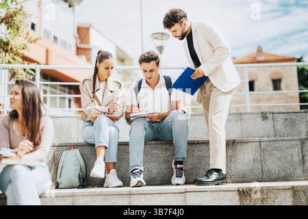 High school students collaborating with professor's guidance outdoors Stock Photo