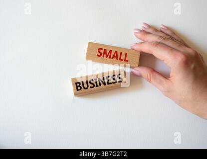 Small business symbol. Concept words Small business on wooden blocks. Beautiful white background. Businessman hand. Business and Small business concep Stock Photo