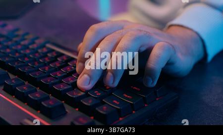 Close up male hand typing computer keyboard working online studying internet e-learning hacker programmer unrecognizable man guy gamer playing video Stock Photo