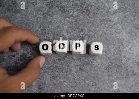 male hand placing the wooden cubes with the word on the table. apologize for a mistake or error Stock Photo