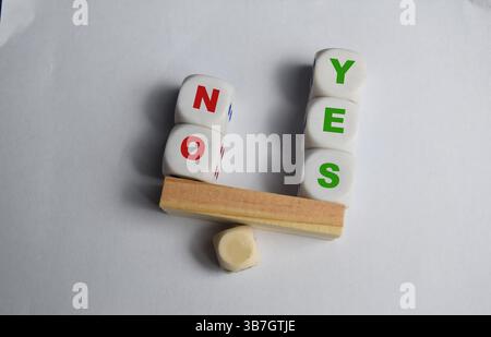 Yes or No inscription on wooden cubes on a seesaw with yess outweight no. The concept of positivy or positive attitude in life Stock Photo