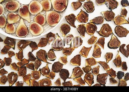 Dried figs lie next to fresh ones on the table. Stock Photo